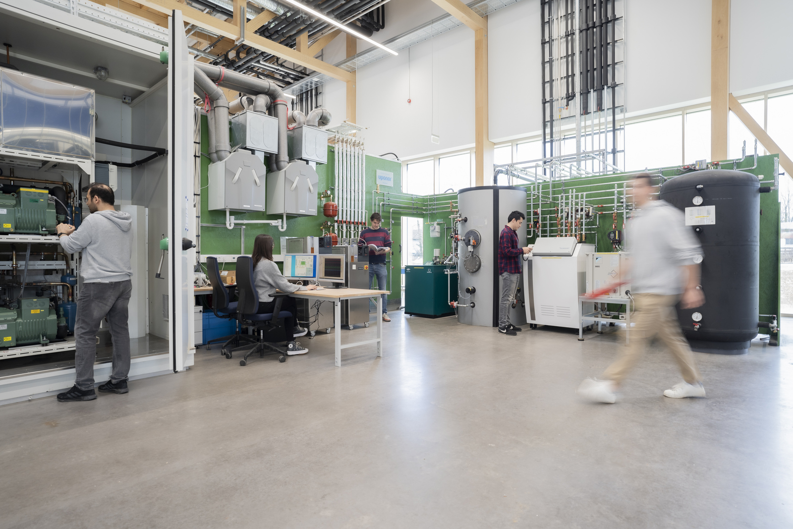 Menschen in einem Technikum arbeiten an einer Heizungsanlage